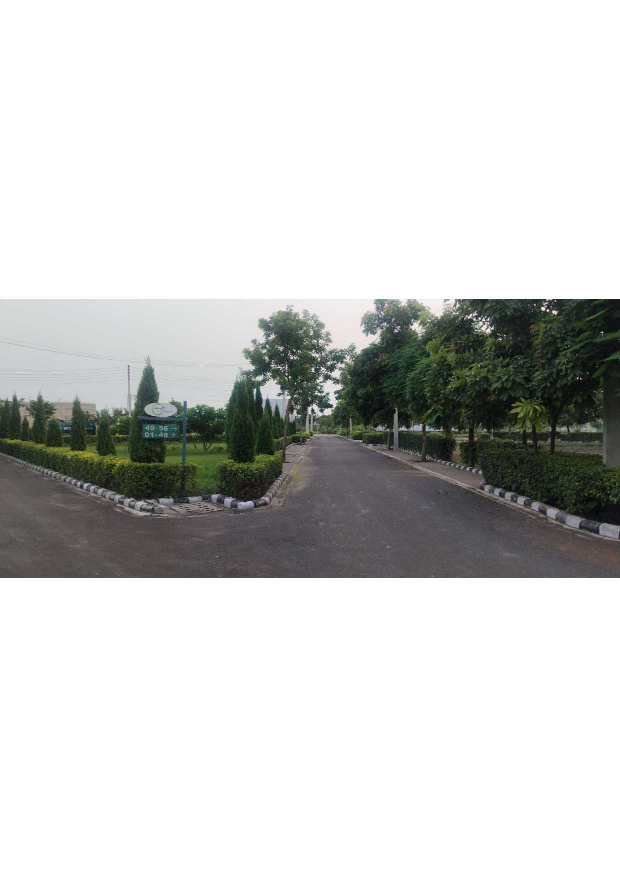 Green Circle Homes, Ambala – landscaped junction with plot direction signboard