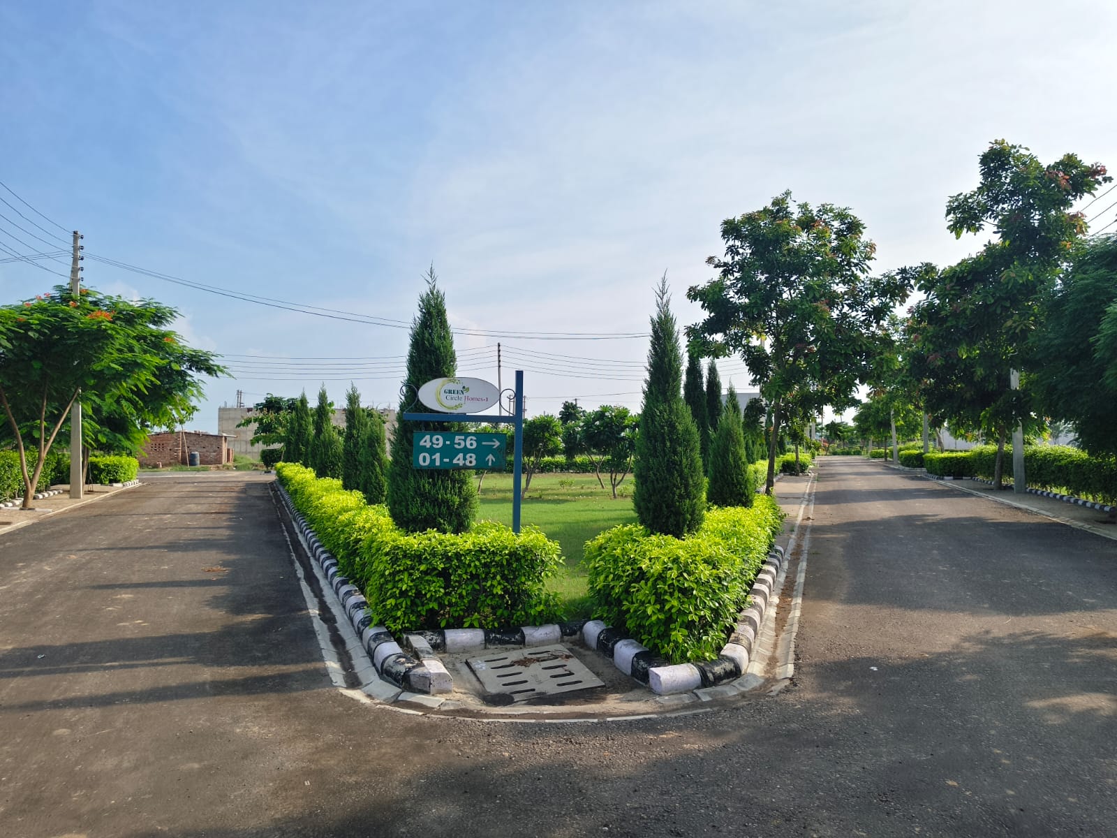 Green Circle Homes, Ambala – landscaped junction with plot direction signboard